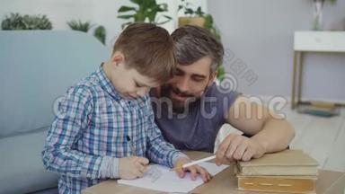 可爱的孩子<strong>初中</strong>生正在和他的父亲一起在练习本上写作业。 教育、儿童
